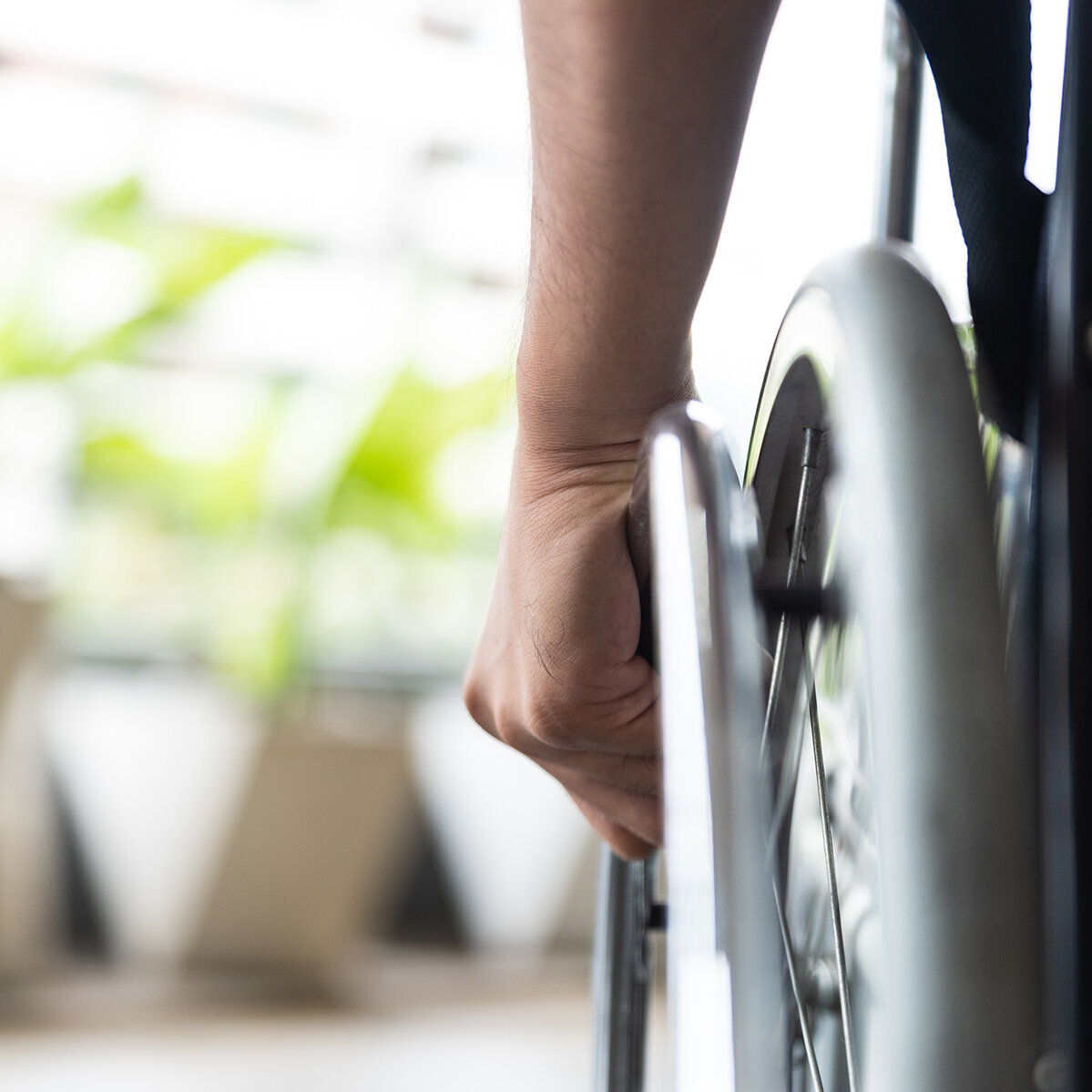 Rad eines Rollstuhles mit Hand daran